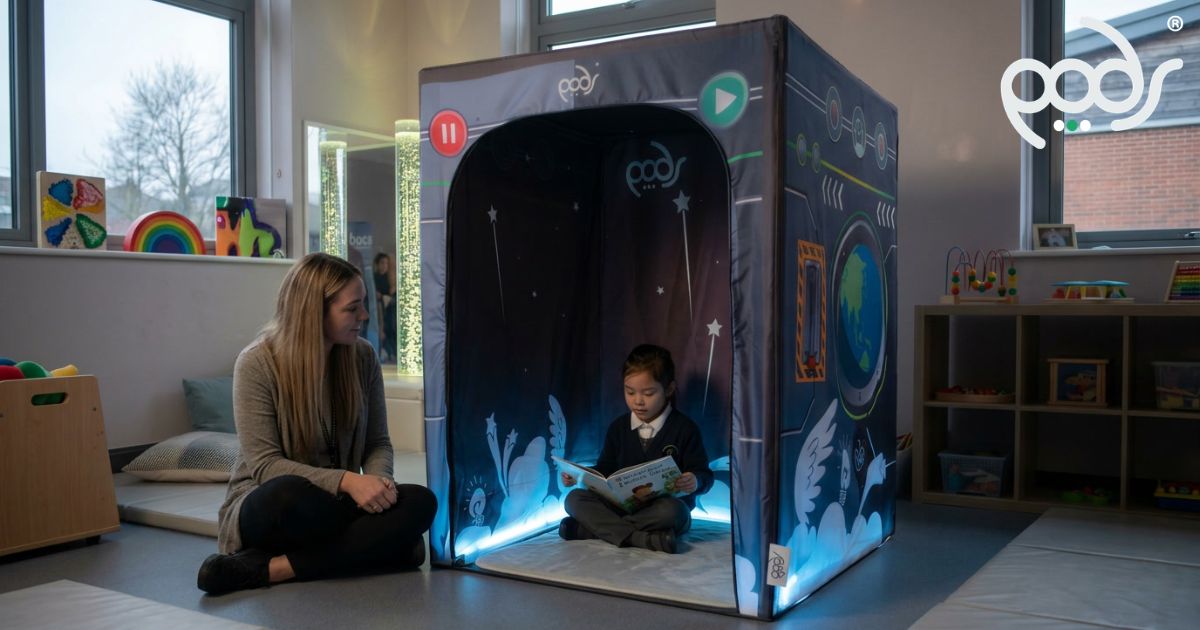 Child reading inside a correctly scaled PODSgo Blackout sensory tent in a special-school classroom.