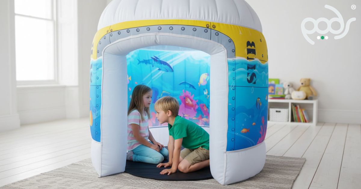 Two children exploring inside a full-size PODS Sub Aqua Quest sensory play tent in a bright playroom.