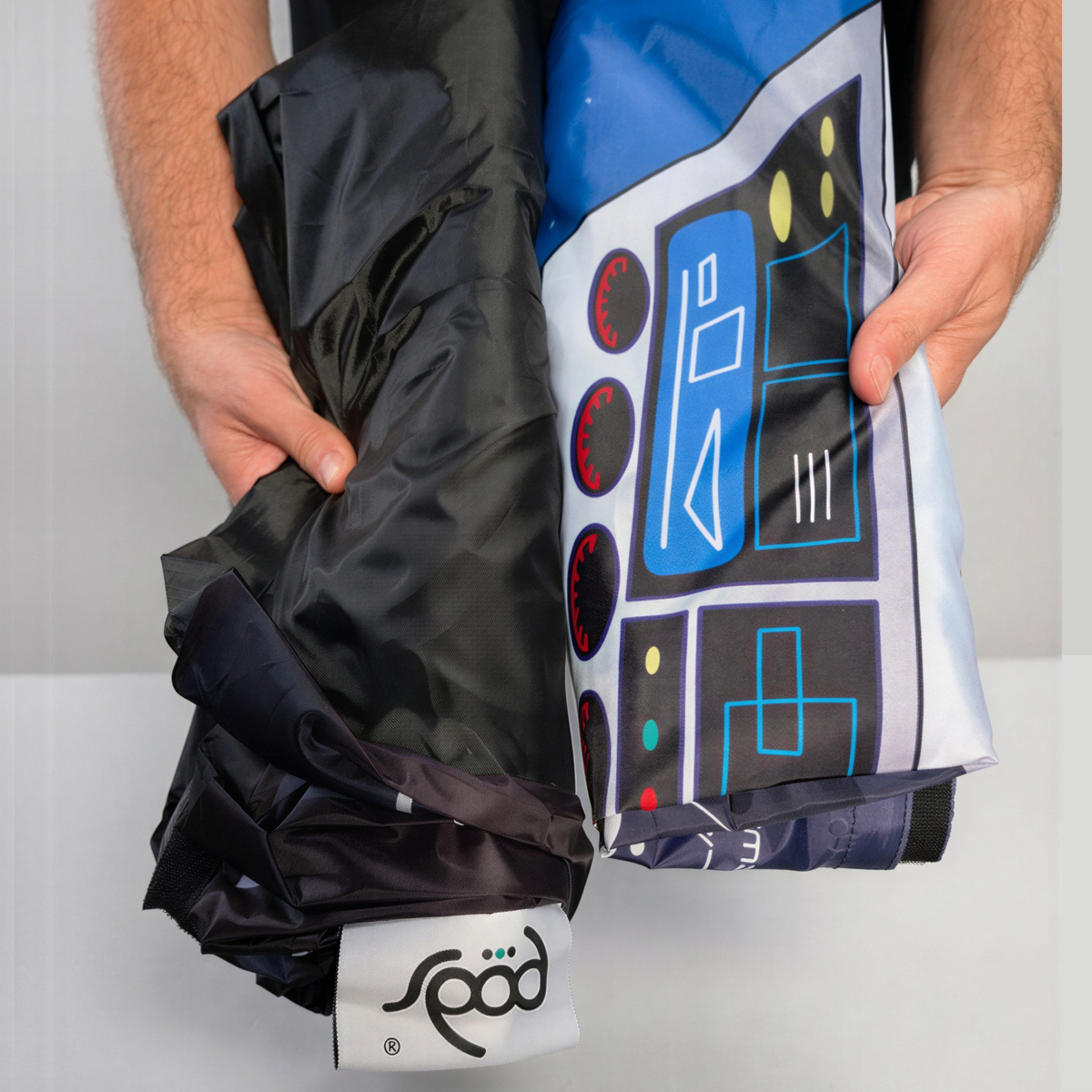 Folded PODSgo Galactic Space Adventure Jacket Set, black inner jacket beside the printed spaceship control panel outer jacket